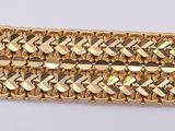 a close up of a gold bracelet on a white surface