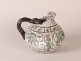 a white pitcher with a green and blue design on it
