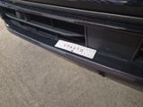 the front bumper of a black car with a sticker on it ' s bumper