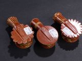 three cupcakes that are shaped like guitars on a table