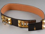 a black and gold belt with gold rivets on it