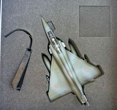 une maquette d'avion de chasse posée par terre