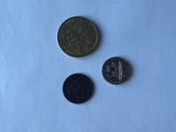 three coins are shown on a white surface with a blue background
