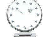 une horloge en argent ornée d'étoiles, posée sur un socle