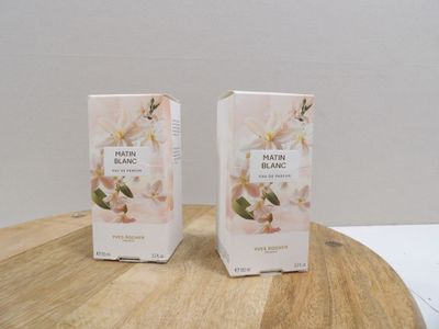 deux boîtes de parfum posées sur une table en bois