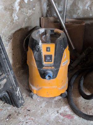 un aspirateur jaune et noir posé dans un coin d'une pièce