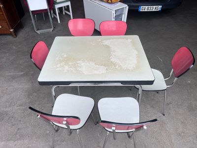 a table and four chairs in a room with a car in the background