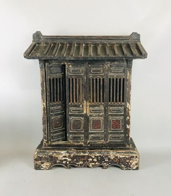 an old black and white wooden cabinet with a door and a window