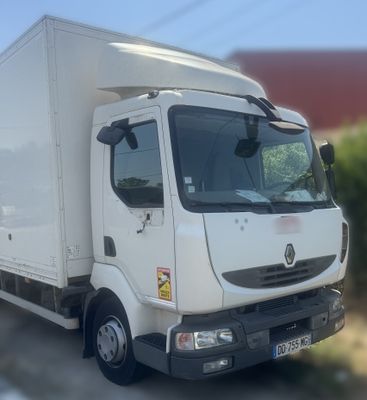 un camion blanc garé sur le bord de la route
