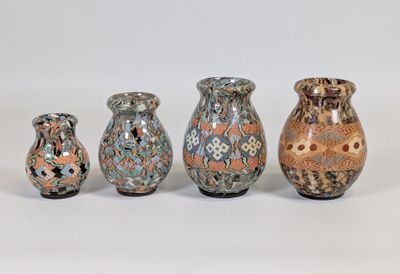trois vases sont posés les uns à côté des autres sur une surface blanche