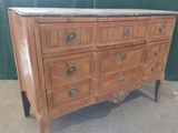 a wooden dresser with a marble top on it