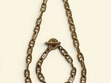 a close up of a necklace and bracelet on a white surface