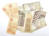 une pile de vieux billets posée sur une surface blanche