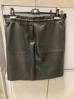 une jupe en cuir noir suspendue à un cintre dans une cuisine