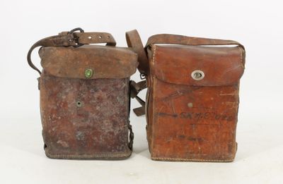 two old leather bags sitting side by side on a white surface