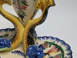 a vase with two birds on it and a plate with a bird on it