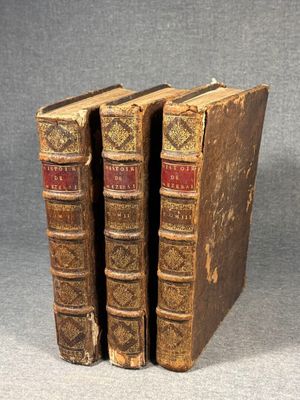 two old books sitting on top of each other on a table