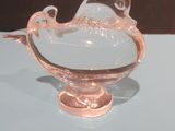 a glass bowl with a bird on it on a table