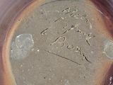 a brown plate with writing on it sitting on a table