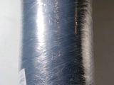 a roll of blue yarn wrapped in plastic on a shelf