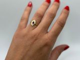 woman ' s hand with red manicured nails and a gold ring
