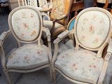 plusieurs chaises et une table dans une pièce avec beaucoup de meubles