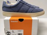 les baskets bleues sont posées sur une boîte, posée elle-même sur une surface blanche