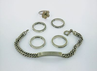 an assortment of silver rings and bracelets on a white surface