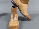 pair of men ' s tan and brown leather shoes on a gray surface