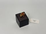 une photo d'une bague dans une boîte noire, avec une étiquette de prix
