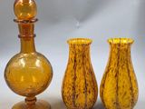 deux vases en verre jaune posés l'un à côté de l'autre sur une table