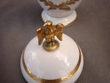 two white vases with gold decorations on them