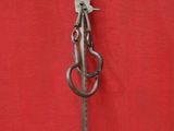 a metal pole with a metal handle on a red wall