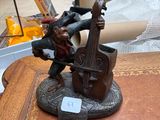 une figurine représentant un homme jouant du violon, posée sur une table