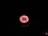 a close up of a pink diamond on a black surface