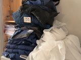 a stack of folded clothes on a shelf in a room