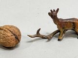 figurine of a deer and a walnut on a white surface