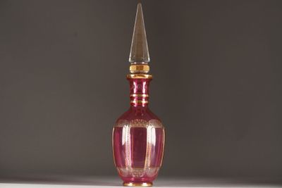 a pink glass bottle with a gold top on a table