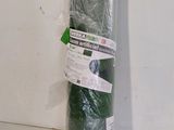 a roll of green tarp wrapped in plastic on a table