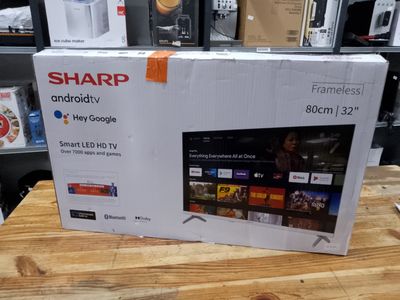 a box of sharpr smart tvs on a wooden table