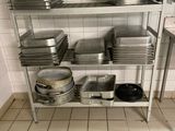 many pans and pans on a metal shelf in a kitchen