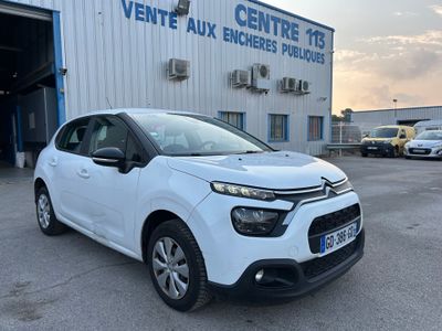 une citrole blanche garée devant un immeuble