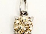 a close up of a diamond pendant on a white surface