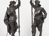 paire de figurines anciennes en bronze représentant un homme et une femme tenant des torches