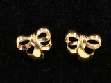 deux paires de boucles d'oreilles en forme de nœud dorées sur fond noir