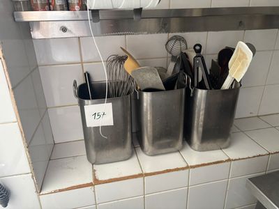 de nombreux ustensiles rangés dans un récipient en métal posé sur le plan de travail