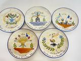 quatre assiettes à motifs différents posées sur une surface blanche