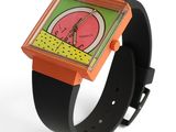 une montre orange et verte dont le cadran comporte une horloge