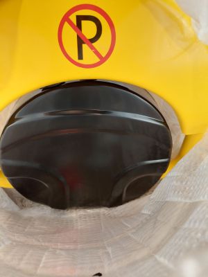 un casque jaune sur lequel est apposé un panneau « Stationnement interdit »