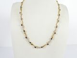 un collier de perles dorées et noires sur un mannequin